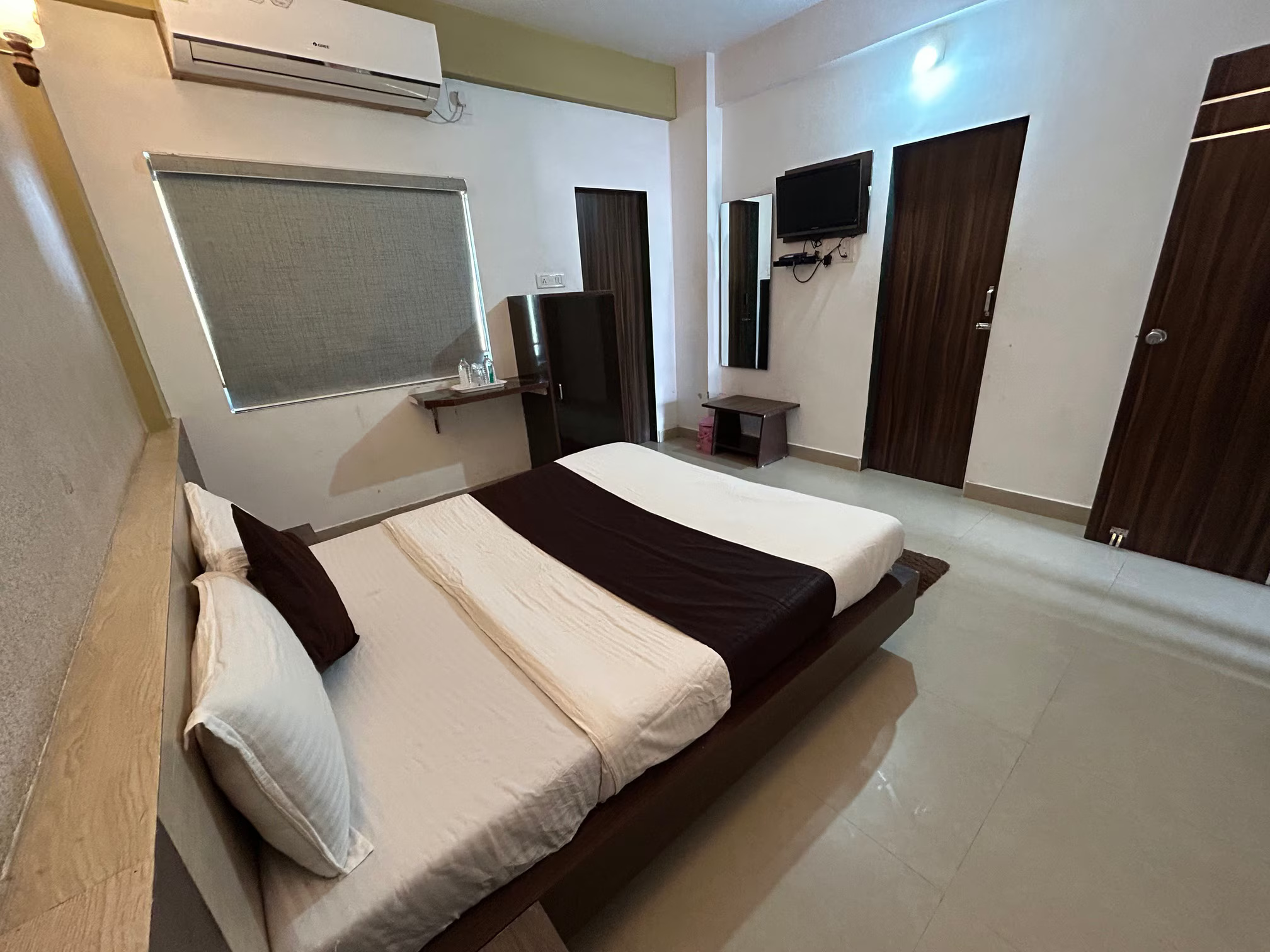 Bright double AC room at Hotel Somnath Atithigruh with a window view, offering natural light and a refreshing ambiance.